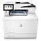 Фото-2 МФУ HP Color LaserJet Enterprise M480, вид спереди: выносной сенсорный экран слева и USB‑порт под ним, сверху автоподатчик, внутри виден лист на стекле сканера; важно для оценки интерфейса управления и зоны сканирования.