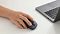 Фото-6 Мышь Xiaomi Wireless Mouse Comfort Edition, демонстрация использования в руке рядом с ноутбуком; на фото видны чёрный корпус, колесо прокрутки и рабочее положение пальцев на кнопках; изображение важно для страницы товара, потому что показывает контекст использования мыши на столе.