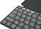Фото-2 Клавиатура Logitech Keys-To-Go 2, крупный план левого верхнего угла; показаны клавиши Esc, F1–F4, русско-английские символы и матовая тёмно-серая поверхность клавиш рядом с крышкой-обложкой. Полезно для страницы товара, чтобы показать маркировку верхнего ряда и форму клавиш.