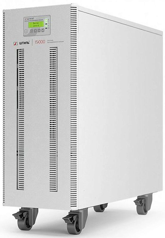 Фото-1 ИБП Штиль ST3115L 15000, вид спереди под углом; на фото светло-серый tower-корпус на колёсах, верхний LCD-экран и две длинные вертикальные вентиляционные решётки на передней панели; изображение на белом фоне для карточки товара, показывает габаритный башенный корпус и элементы индикации, что важно для подбора по размещению.