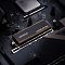 Фото-8 SSD ADATA LEGEND 960 MAX, модуль удерживается рукой над внутренним отсеком устройства; видны чёрный радиатор, открытые контакты M.2 и посадочное место, внизу частично показан игровой контроллер. Фото показывает сценарий установки накопителя в компактное устройство для страницы товара.