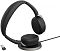 Фото-4 Наушники Jabra Evolve2 65 Flex, вид на зарядной площадке: чёрная гарнитура с поднятыми чашками над круглой настольной базой, рядом показан USB-адаптер; изображение важно для демонстрации способа зарядки модели.