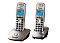 Фото-2 DECT‑телефон Panasonic KX‑TG2512RU: две трубки на базах, ракурс 3/4; светло‑бежевые корпуса, синяя подсветка дисплеев, крупная круглая навигационная клавиша; на белом фоне — важно для оценки оттенка и формы комплекта под углом.