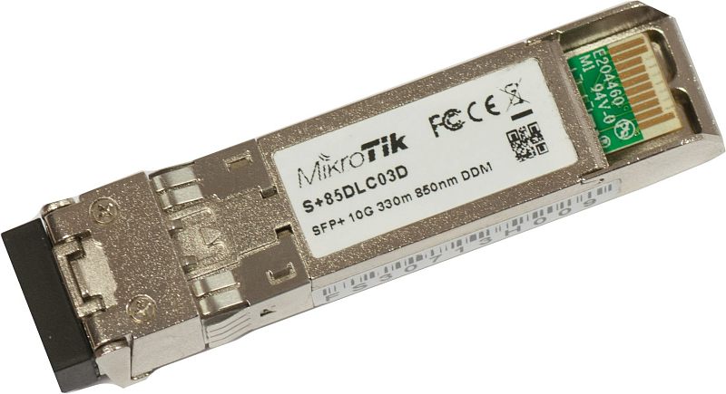 Фото-1 Трансивер MikroTik S+85DLC03D SFP+, вид под углом: серебристый корпус с наклейкой S+85DLC03D, с одной стороны чёрная заглушка оптического порта, с другой — видны контактные площадки; на белом фоне — помогает визуально распознать SFP+ модуль и ориентацию контактов при установке.