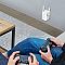 Фото-5 Wi-Fi усилитель сигнала TP-Link RE205, демонстрация использования в комнате: устройство подключено к розетке на стене рядом с игровой зоной, белый корпус