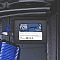 Фото-4 SSD Patriot P210 2TB, накопитель на фоне материнской платы. Видны синяя наклейка на лицевой стороне, тёмный корпус и внутренние компоненты ПК вокруг. Фото важно для страницы товара, потому что показывает устройство в контексте сборки компьютера.