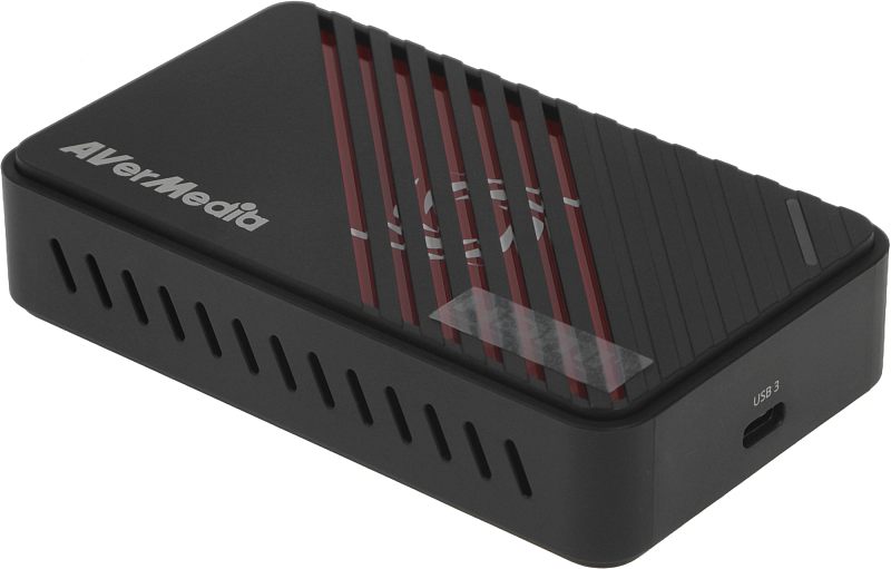 Фото-1 Карта видеозахвата AVerMedia Live Gamer Ultra S, вид сверху под углом. На фото компактный чёрный корпус с диагональными рёбрами, красными полосами и логотипом AVerMedia; изображение показывает внешний дизайн устройства на странице товара.