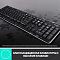 Фото-8 Клавиатура Logitech 920-003381, крупный план под углом: чёрная клавиатура с каплями воды на поверхности, на изображении есть подпись про влагозащиту; показывает высокие клавиши и ситуацию с проливом жидкости.