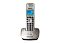 Фото-2 DECT‑телефон Panasonic KX‑TG2511RU: вид спереди, трубка на базе; бежево‑платиновый корпус, синяя подсветка экрана, блок клавиш с центральным джойстиком; на белом фоне — важно для сравнения фронтального вида и оттенка корпуса.