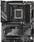 Фото-2 Материнская плата Gigabyte B650 GAMING X AX V2, вид сверху ближе к сокету: кожух VRM с надписью GAMING, сокет AM5 и 4 слота DDR5, радиатор M.2 над основным слотом PCIe; на белом фоне для детализации зоны процессора и охлаждения.